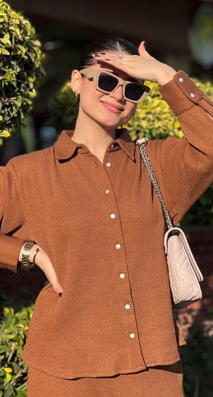 Tan brown knit co-ord set with sunglasses and a quilted shoulder bag