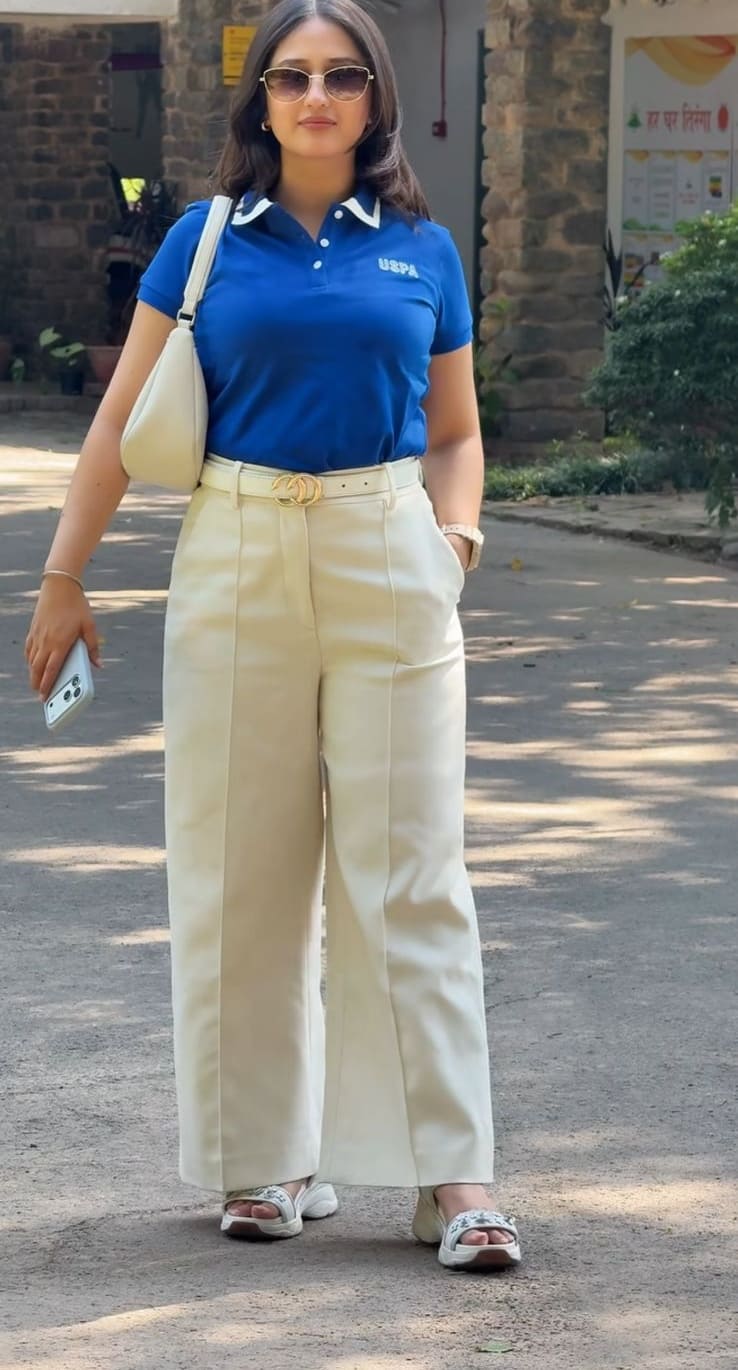 Royal blue polo t-shirt with cream high-waist wide-leg pants and white sling bag
