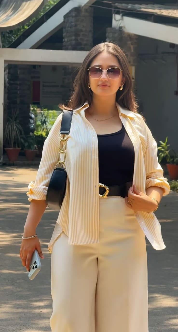 Yellow striped shirt over black tank with cream wide-leg pants and gold-buckle belt